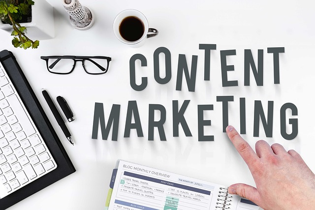 An image of a desk with office tools scatter and a hand pointing at a words "content marketing." How to Get on First Page of Google