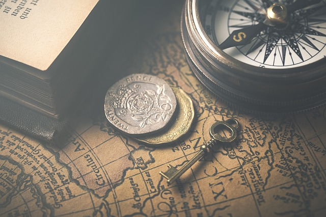An image of a vintage map, compass, key, coins and a book